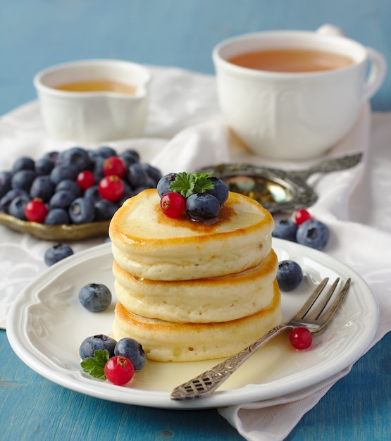 Pila di pancake con bacche fresche e miele