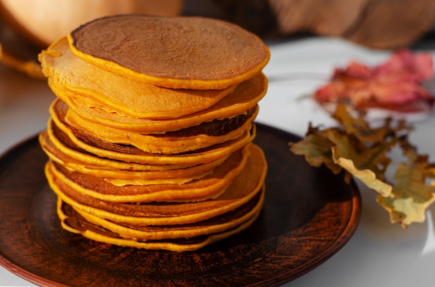 Pila di pancake deliziosi su un piatto marrone