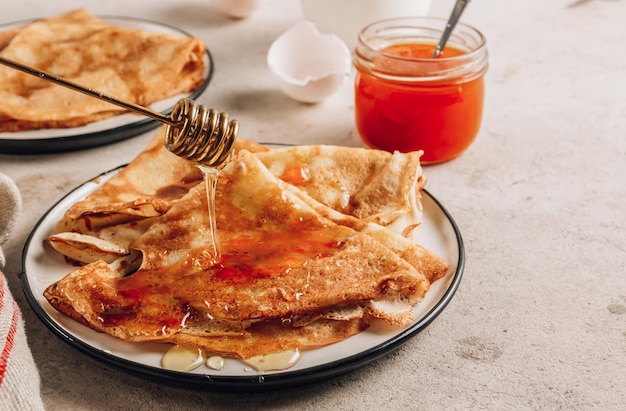 Pila di pancake sottili tradizionali per la settimana dei pancake russi Crepes fatte in casa con marmellata di olivello spinoso e latte per colazione Focus selettivo