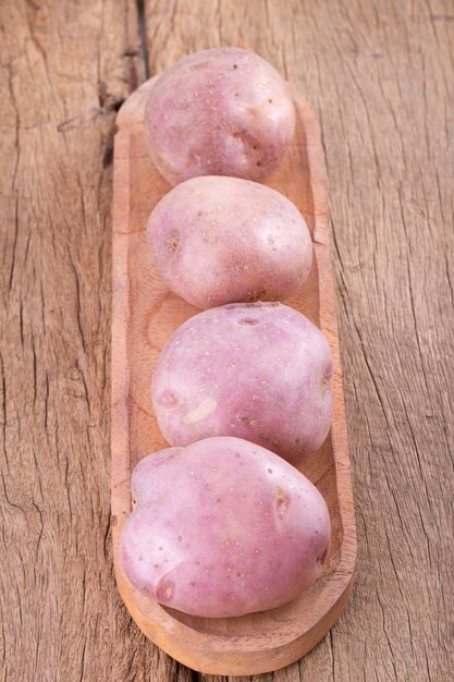 Pila di patate sul tavolo di legno Solanum tuberosum