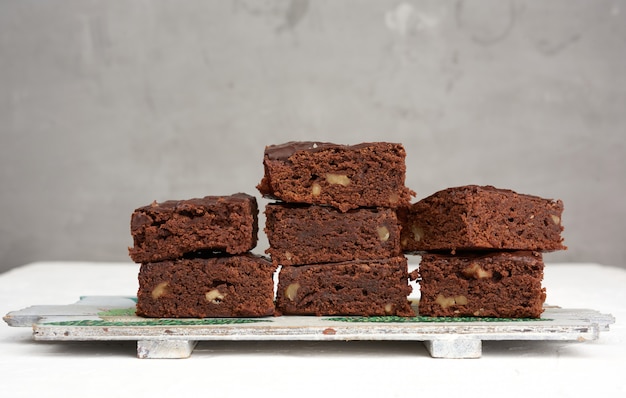 Pila di pezzi al forno quadrati di brownie torta al cioccolato con noci