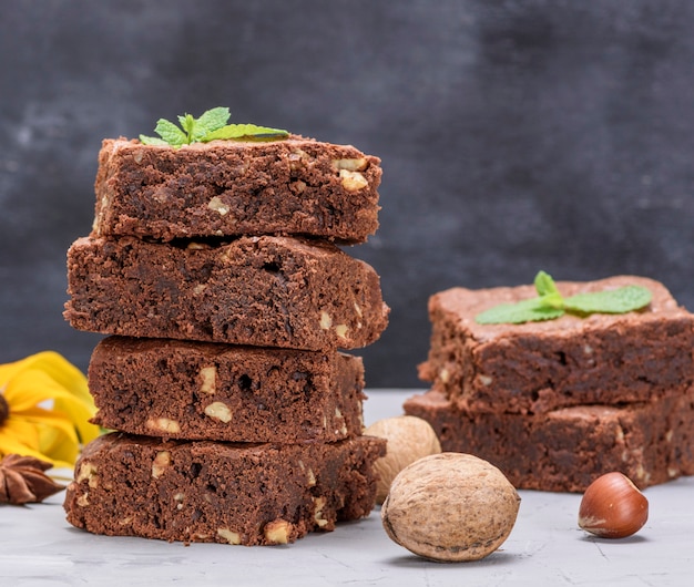 Pila di pezzi quadrati al forno di torta brownie al cioccolato con noci