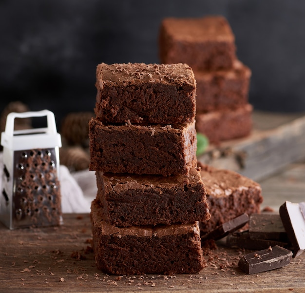 Pila di pezzi quadrati al forno di torta brownie al cioccolato