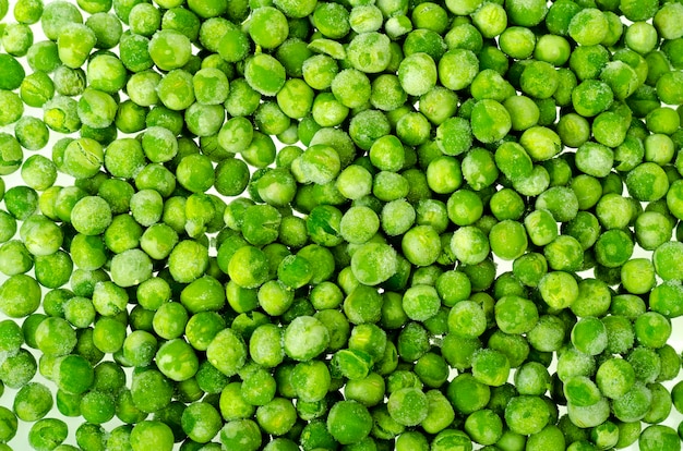 Pila di piselli sbollentati congelati isolati su sfondo bianco. Cibo salutare. Foto di studio