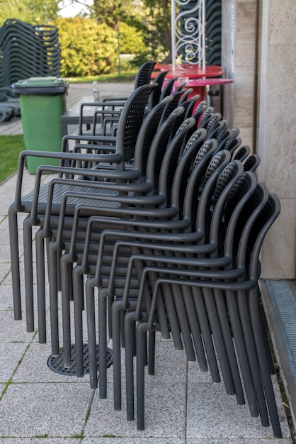 Pila di sedie da giardino grigie poste accanto a un muro dell'hotel