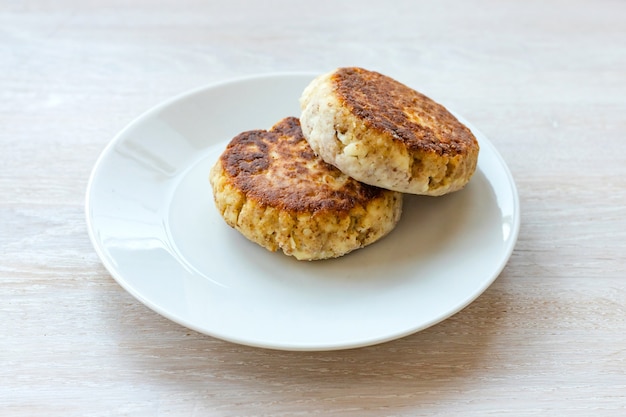 Pila di syrniki delle frittelle della ricotta casalinga sulla zolla sulla tavola bianca. Avvicinamento. Messa a fuoco selettiva. Copia spazio