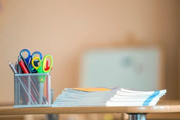 Pila di taccuini e disposizione della cancelleria in aula o in ufficio sul fondo dello spazio della copia