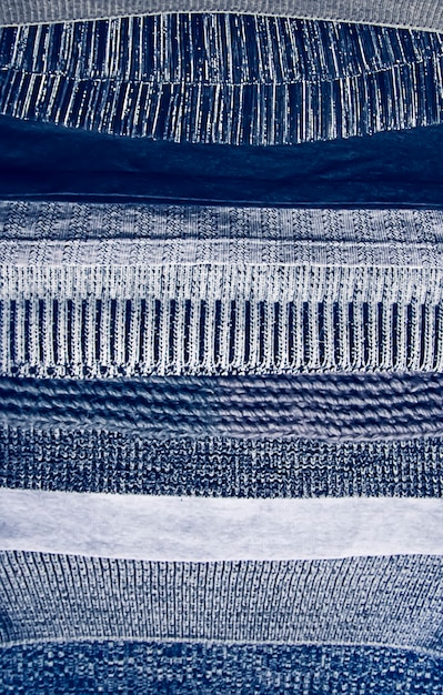 Pila di tessuti a maglia calda con la diversa trama nella tavolozza dei colori grigi da vicino