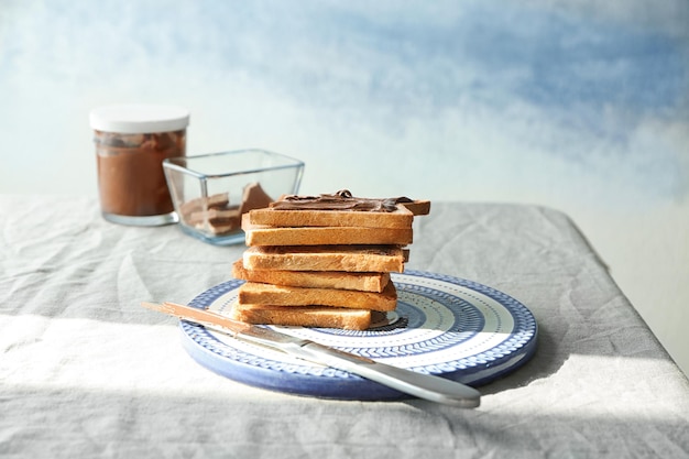 Pila di toast croccanti freschi con pasta di cioccolato sul tavolo