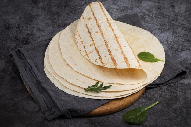 Pila di tortillas di mais su sfondo scuro. Cibo messicano.