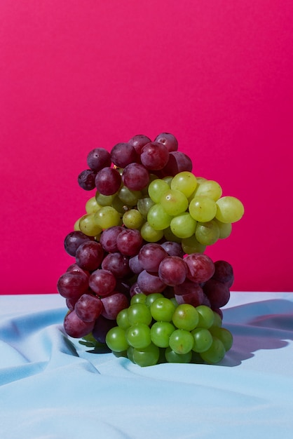 Pila di uva verde e rossa su un drappo blu