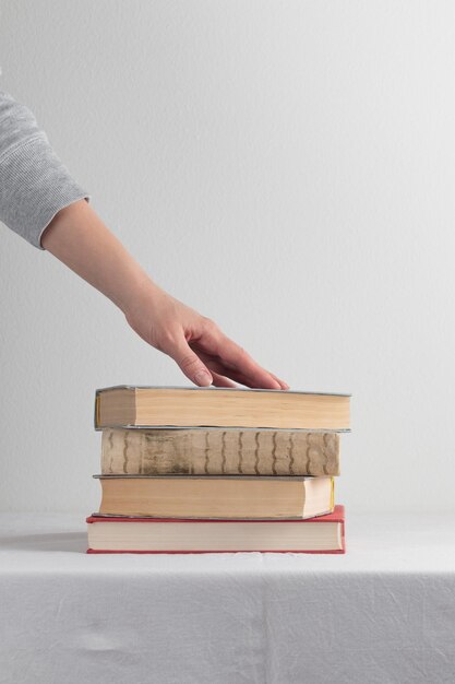 Pila di vecchi libri d'annata rustici con la mano