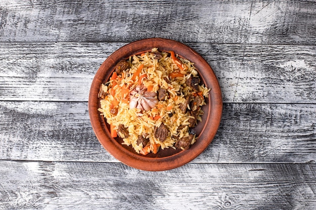 Pilaf con carne di verdure pollo pilaf fatto in casa su uno sfondo di legno bianco