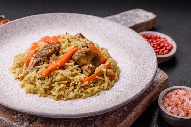 Pilaf delizioso con verdure, sale, spezie e erbe in un piatto di ceramica