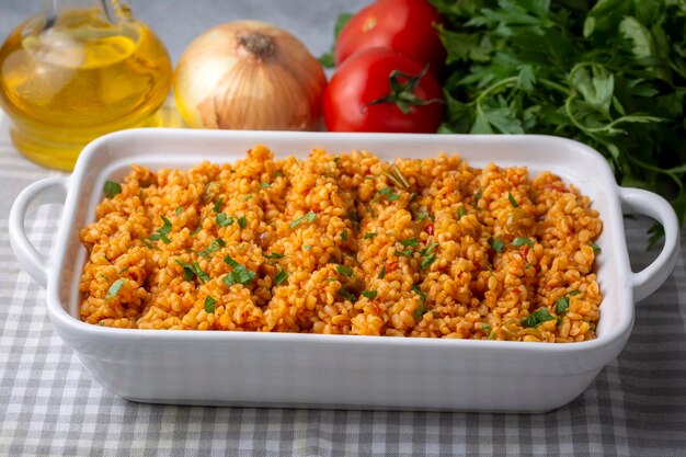 Pilaf turco tradizionale del bulgur con salsa di pomodoro nel piatto nome turco meyhane pilavi