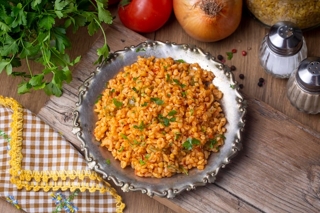 Pilaf turco tradizionale del bulgur con salsa di pomodoro nel piatto nome turco meyhane pilavi