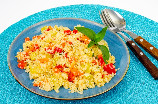 Pilaf vegetariano del cuscus con le verdure sul piatto blu.