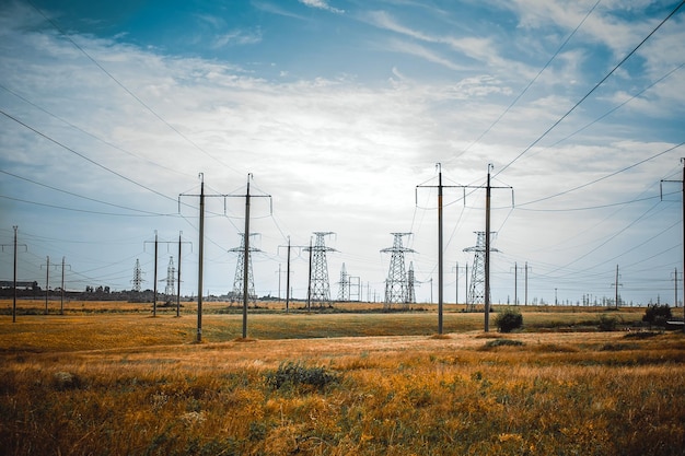 Pilastri elettrici sul campo contro il cielo