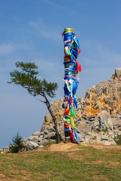Pilastro sciamano con nastri multicolori sullo sfondo del capo Burkhan, isola di Olkhon. 13 pilastri su capo Burkhan, isola di Olkhon.