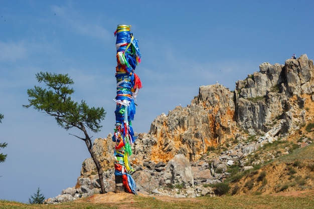 Pilastro sciamano con nastri multicolori sullo sfondo del capo Burkhan, isola di Olkhon. 13 pilastri su capo Burkhan, isola di Olkhon.