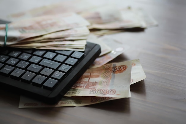 Pile di banconote da 5000 rubli sul tavolo accanto al laptop Risparmio e investimenti in condizioni di sanzioni e inflazione