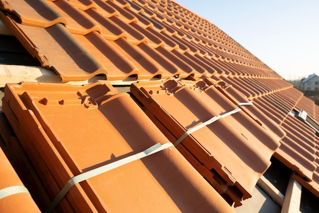 Pile di tegole in ceramica gialla per la copertura del tetto dell'edificio residenziale in costruzione.