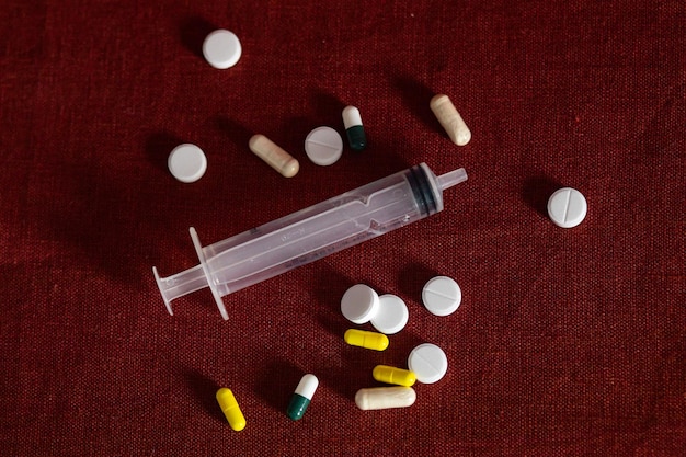Pillole bianche e colorate giacciono su uno sfondo bordeaux giorno della salute medici e medicine che assumono vitamine trattamento delle malattie