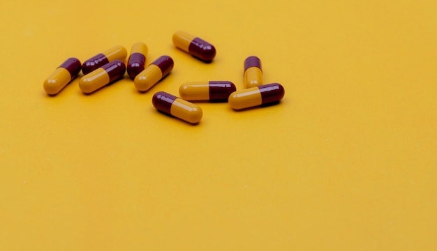 Pillole di capsule antibiotiche Redyellow su sfondo giallo Farmaco da prescrizione Farmaco antibiotico