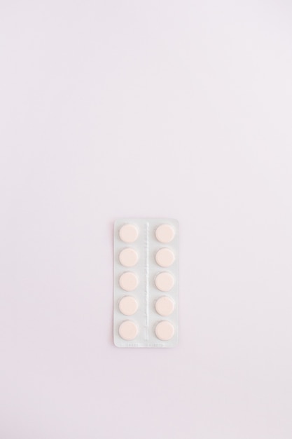 Pillole di medicina piatte sul rosa