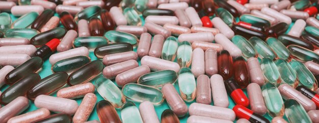 Pillole e capsule multicolori di panorama su sfondo verde