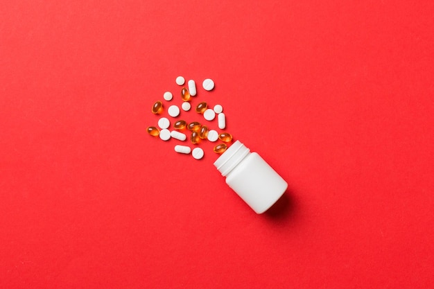 Pillole e capsule multicolori in bottiglia di plastica su sfondo colorato spazio copia molte diverse compresse e pillole medicinali concetto di integratori vitaminici e nutrizionali