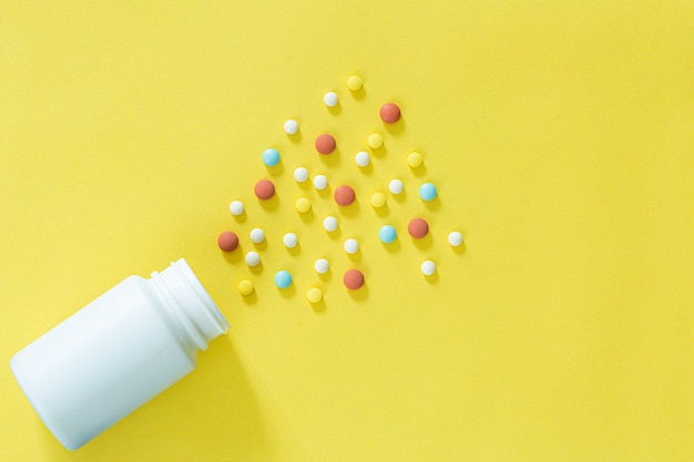 Pillole e flaconi di medicinali su uno sfondo gialloTutti i tipi di farmaci da inserire nella medicina