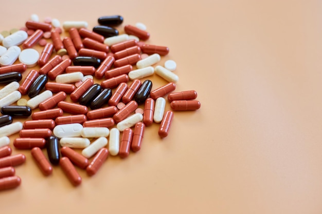 Pillole mediche colorate diverse piatte su sfondo arancione