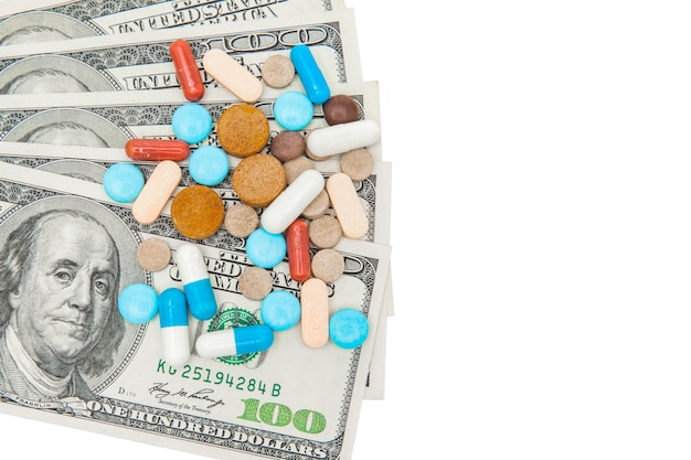 Pillole medicinali colorate e dollari americani su bianco una parete