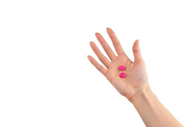 Pillole rosa in mano su uno sfondo bianco isolato