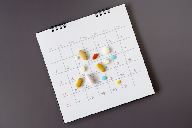 Pillole su uno sfondo di calendario. concetto di assistenza sanitaria