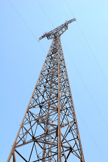 Pilone di elettricità ad alta tensione contro il cielo blu