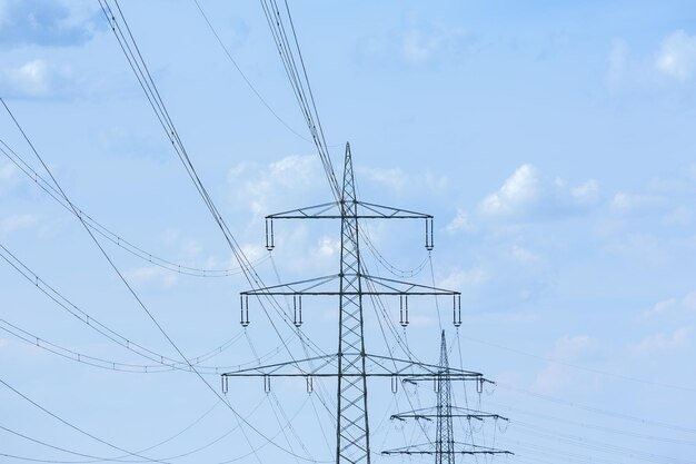 Pilone di elettricità sull'alta tensione dell'industria del cielo nuvoloso blu