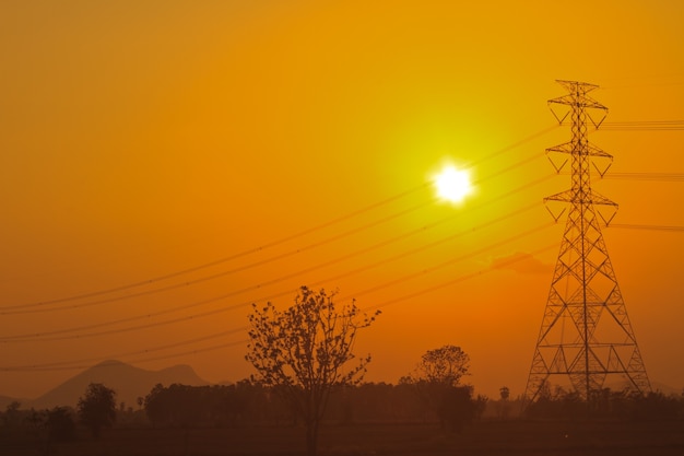 Piloni di potenza ad alta tensione nel tramonto