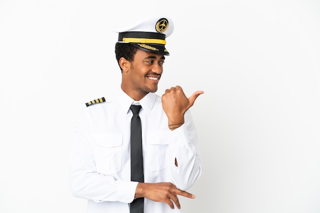 Pilota di aeroplano afroamericano su sfondo bianco isolato rivolto verso il lato per presentare un prodotto