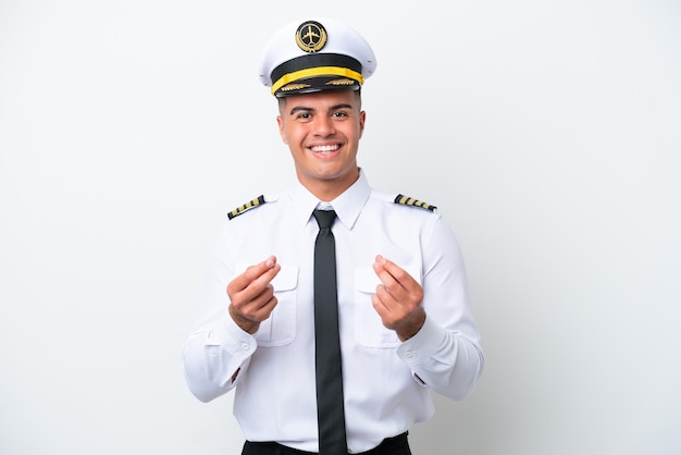 Pilota di aeroplano uomo caucasico isolato su sfondo bianco che fa gesto di denaro