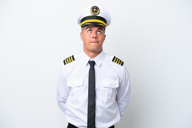 Pilota di aeroplano uomo caucasico isolato su sfondo bianco e alzando lo sguardo