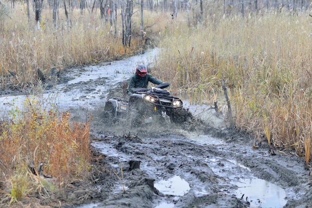 Pilota di ATV e UTV che guida su strade dure d'acqua. Giro fuoristrada estremo. 4x4.