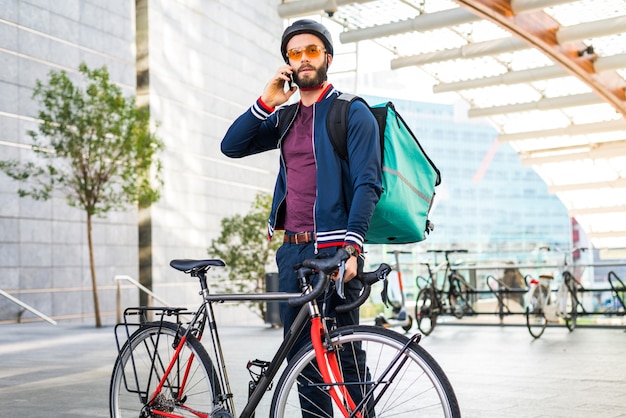 Pilota di servizio di consegna cibo che consegna cibo con la bicicletta