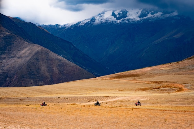 Piloti di moto quard che guidano sul pendio in perù montagnoso