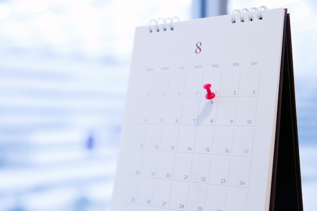 Pin rosso sul calendario per la pianificazione aziendale e la riunione.