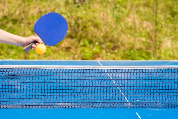 Ping pong o ping pong blu Ping pong all'aperto Ping pong in primo piano Accessori per racchetta e palla da ping pong su un tavolo da ping pong blu Sport