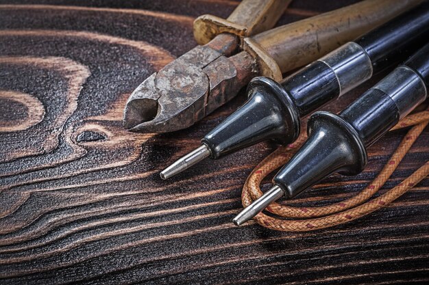 Pinze per tester elettriche vintage sul concetto di elettricità del bordo di legno