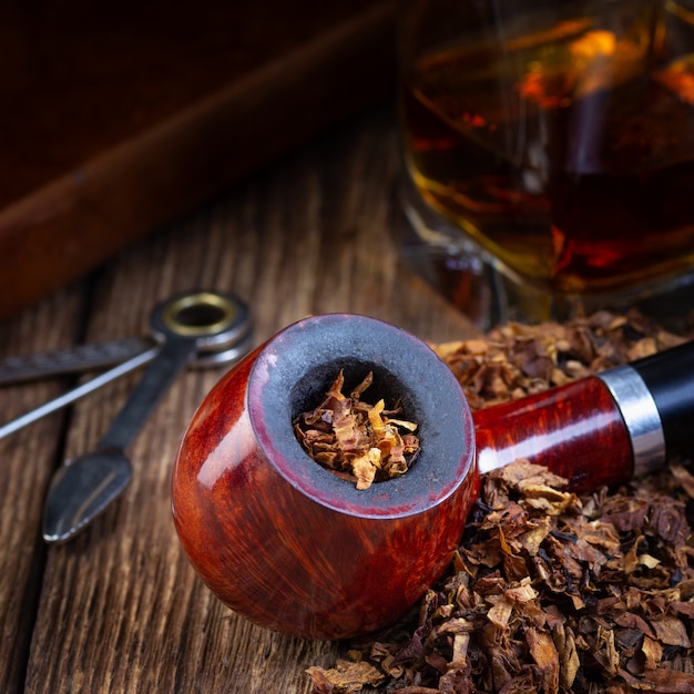 Pipa da fumo laccata e catasta di tabacco