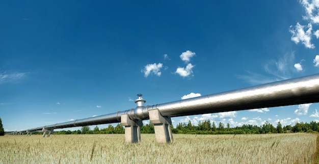 Pipeline sulla strada nel campo, il trasporto di petrolio e gas attraverso i tubi. Tecnologia, politica, materie prime, economia. Copia spazio. Tecnica mista.